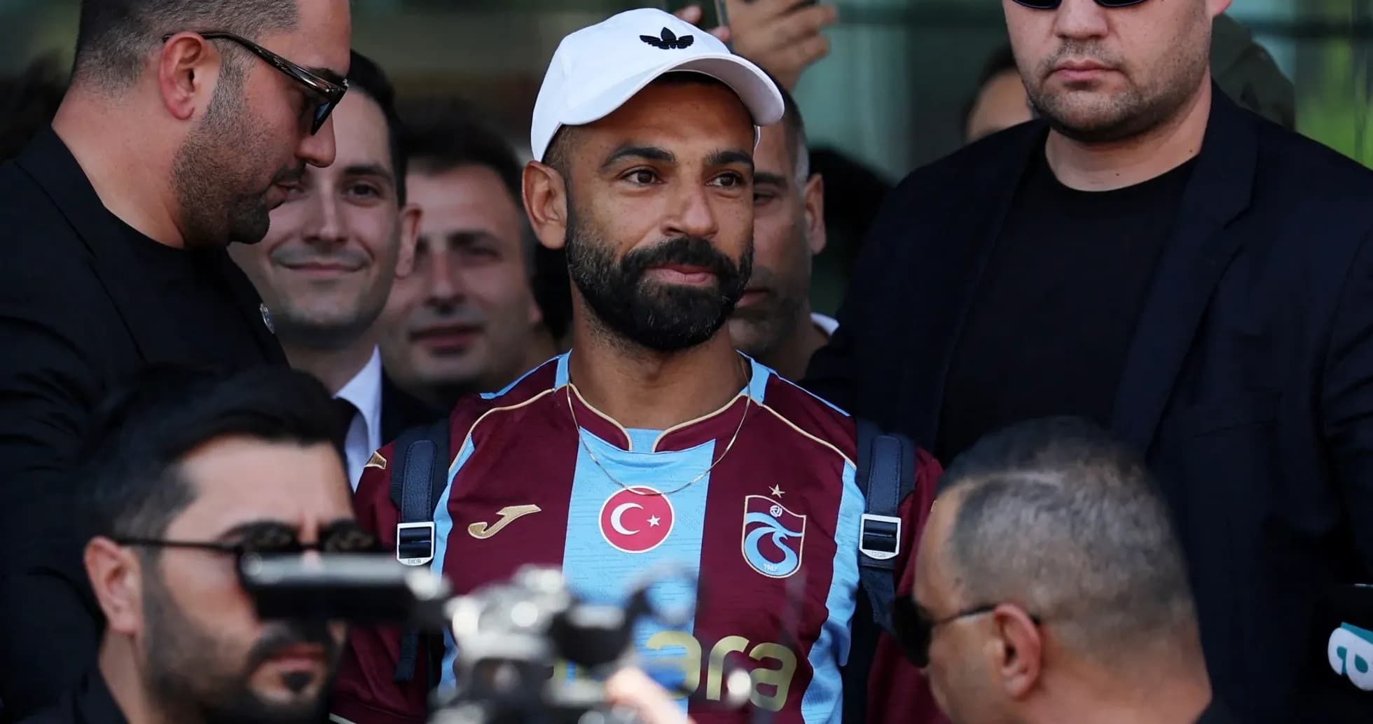 Jugador de Trabzonspor rodeado de seguridad en llegada