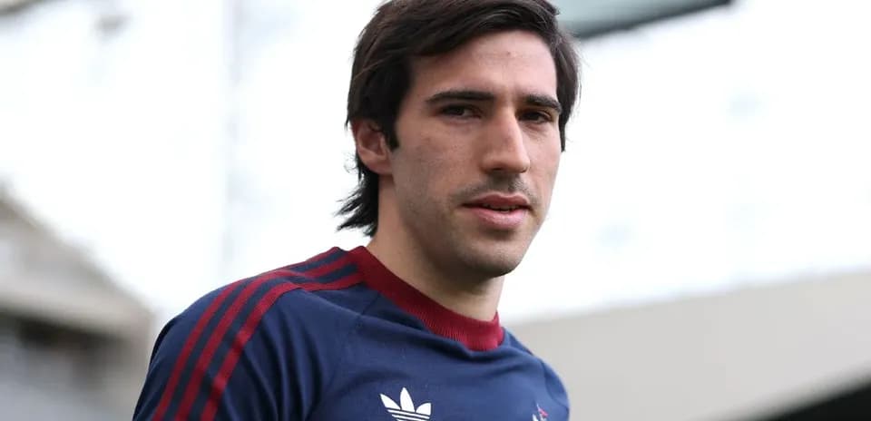 Jugador posando en el estadio con uniforme deportivo