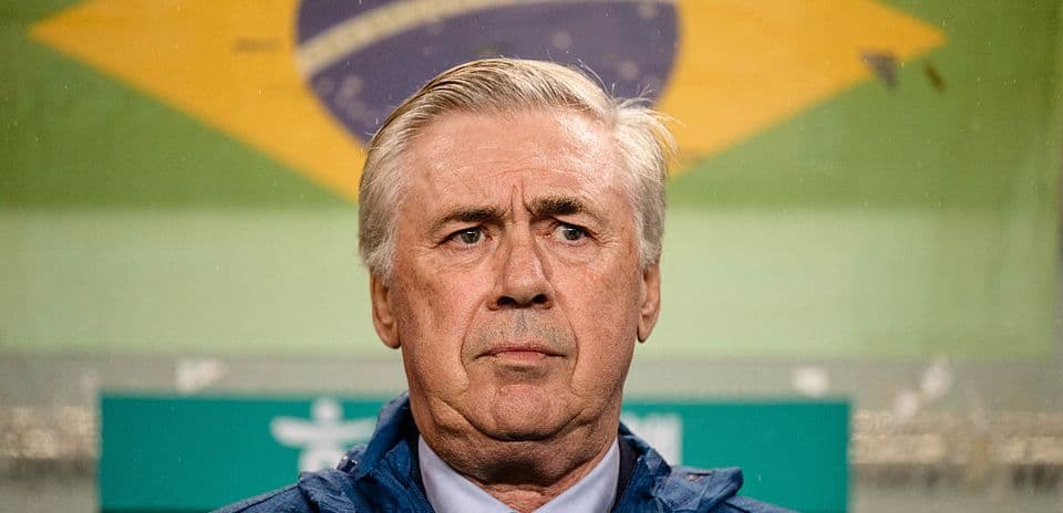 Entrenador en el banquillo con bandera de Brasil
