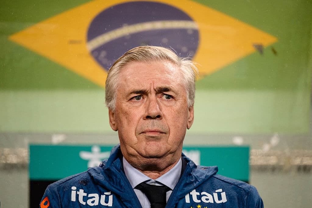 Entrenador en el banquillo con bandera de Brasil