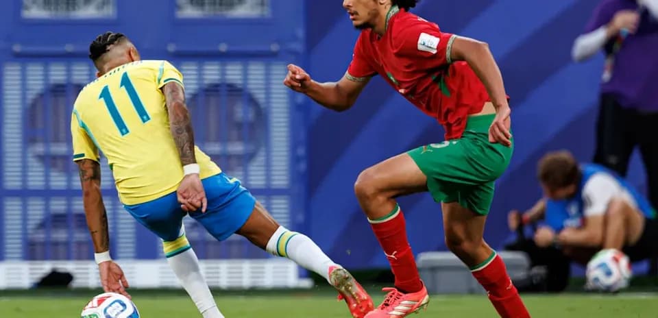 Jugador brasileño evitando a oponente marroquí en el campo