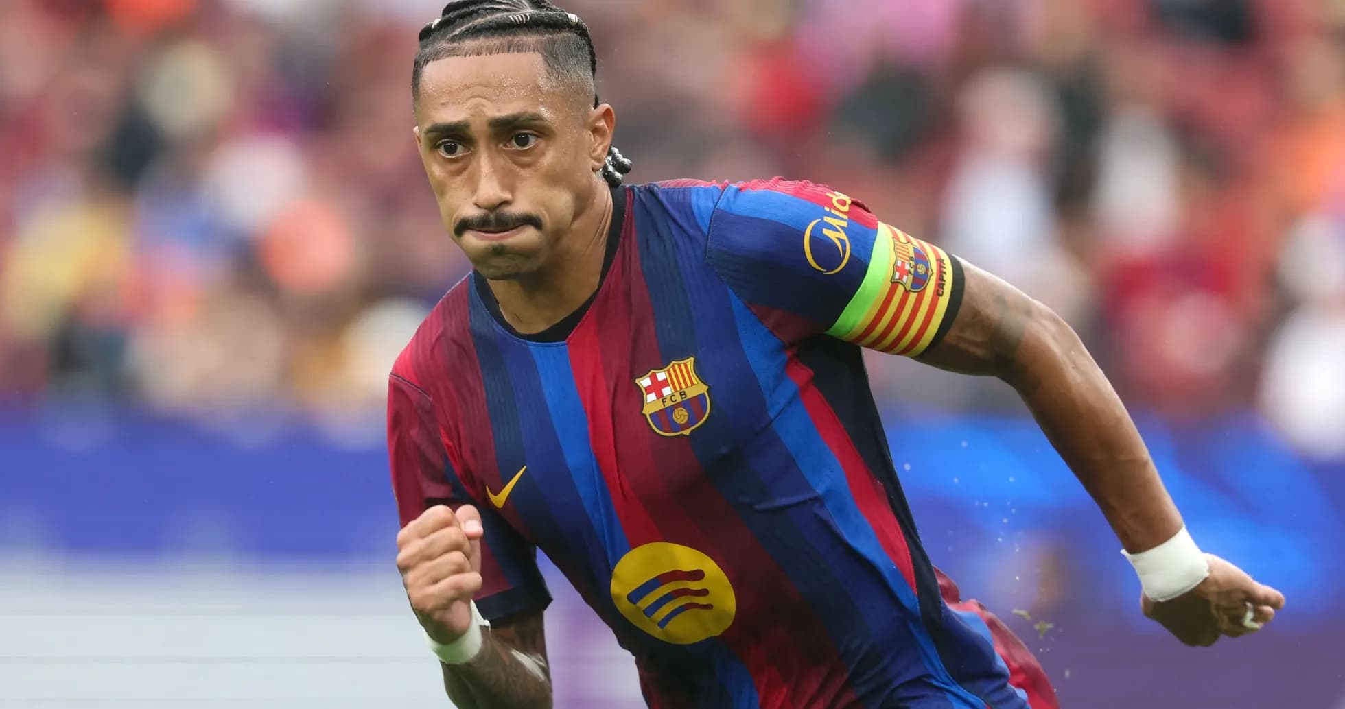 Jugador de Barcelona corriendo con balón en el campo