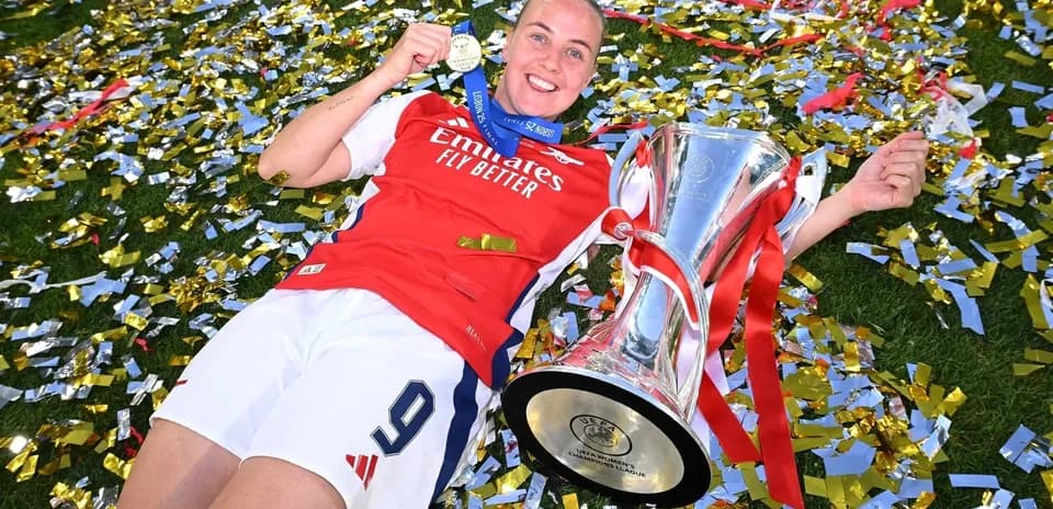 Jugadora de Arsenal con trofeo y medalla de campeón