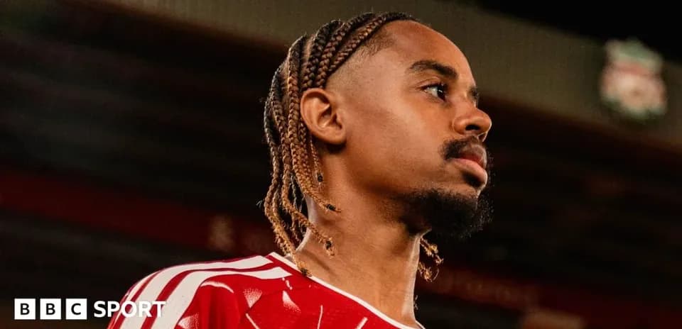 Jugador con trenzas en camiseta roja mirando hacia un lado
