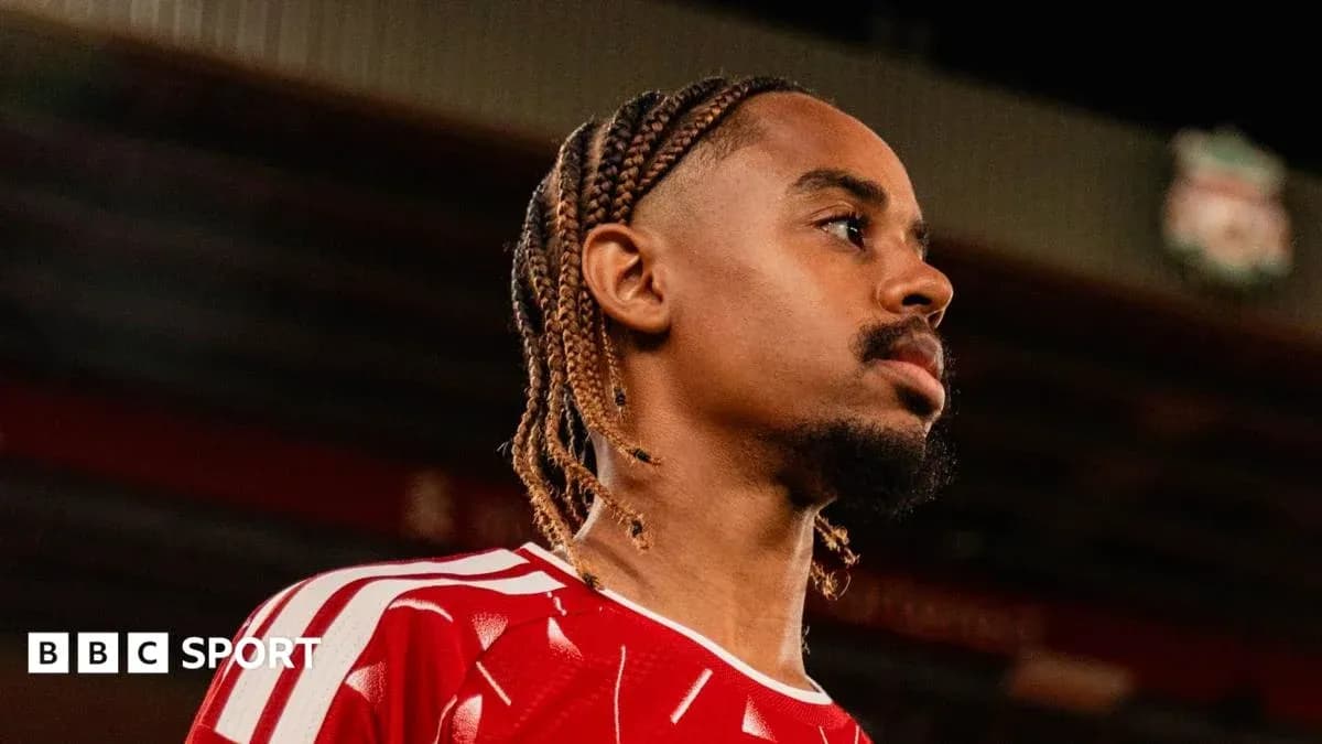 Jugador con trenzas en camiseta roja mirando hacia un lado