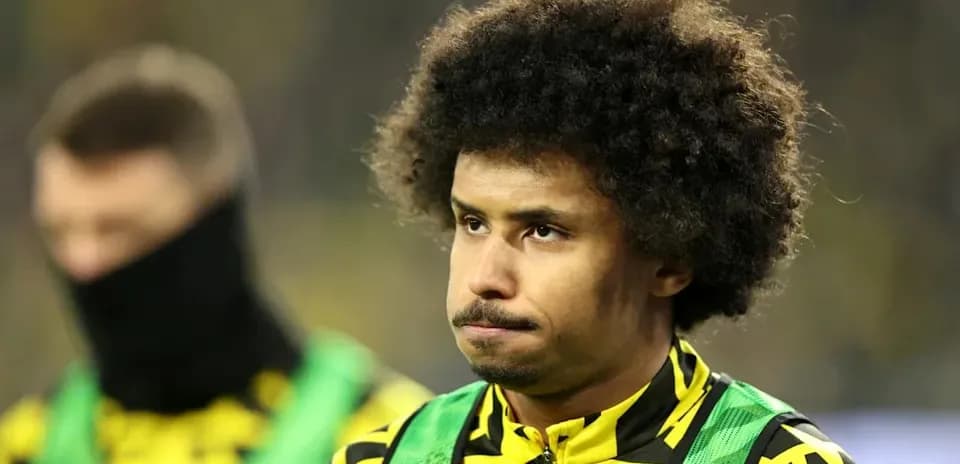Jugador con cabello rizado en la banca de suplentes
