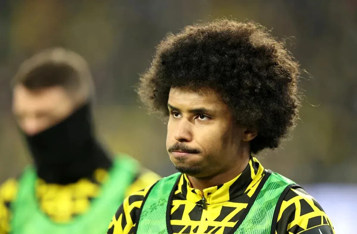 Jugador con cabello rizado en la banca de suplentes