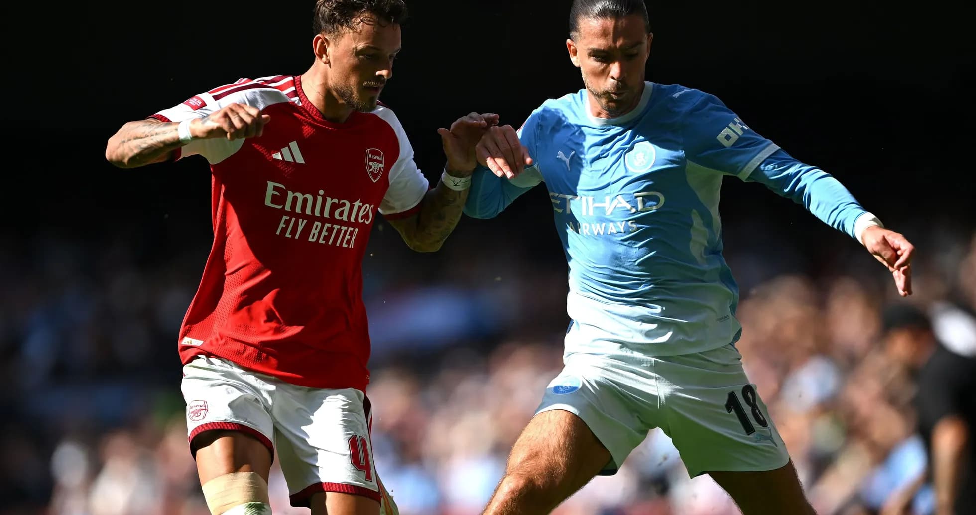 Jugadores de Arsenal y Manchester City compitiendo por el balón Jugadores de Arsenal y Manchester City compitiendo por el balón
