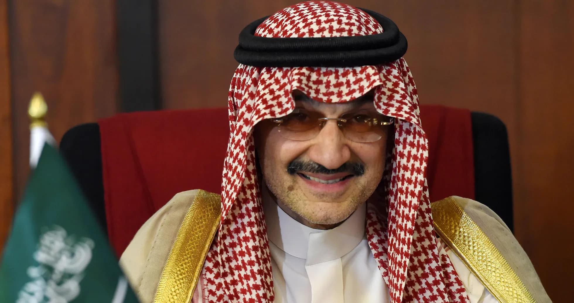 Hombre con keffiyeh sonriendo en una silla Hombre con keffiyeh sonriendo en una silla