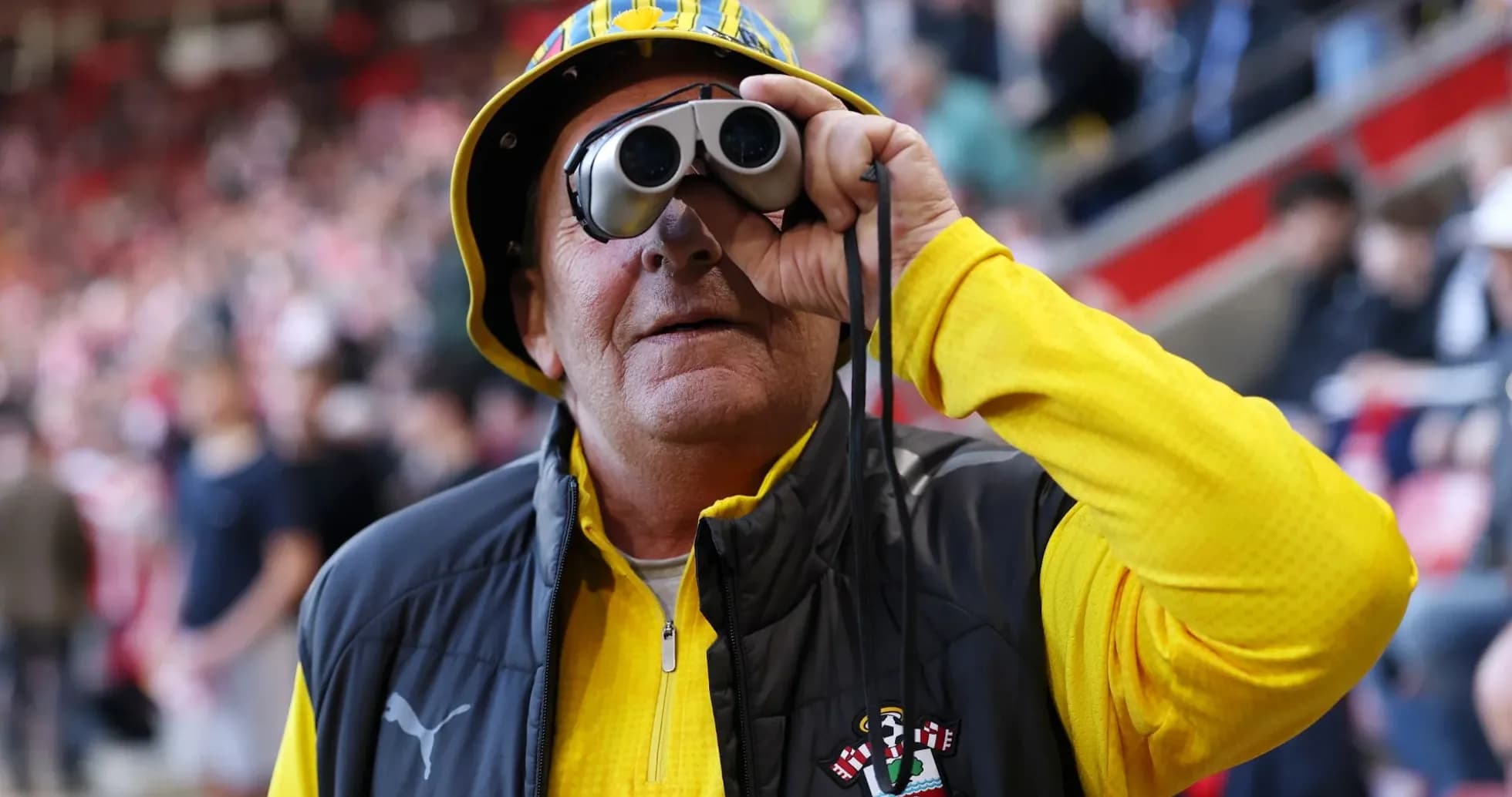 A fan with binoculars at a football match A fan with binoculars at a football match