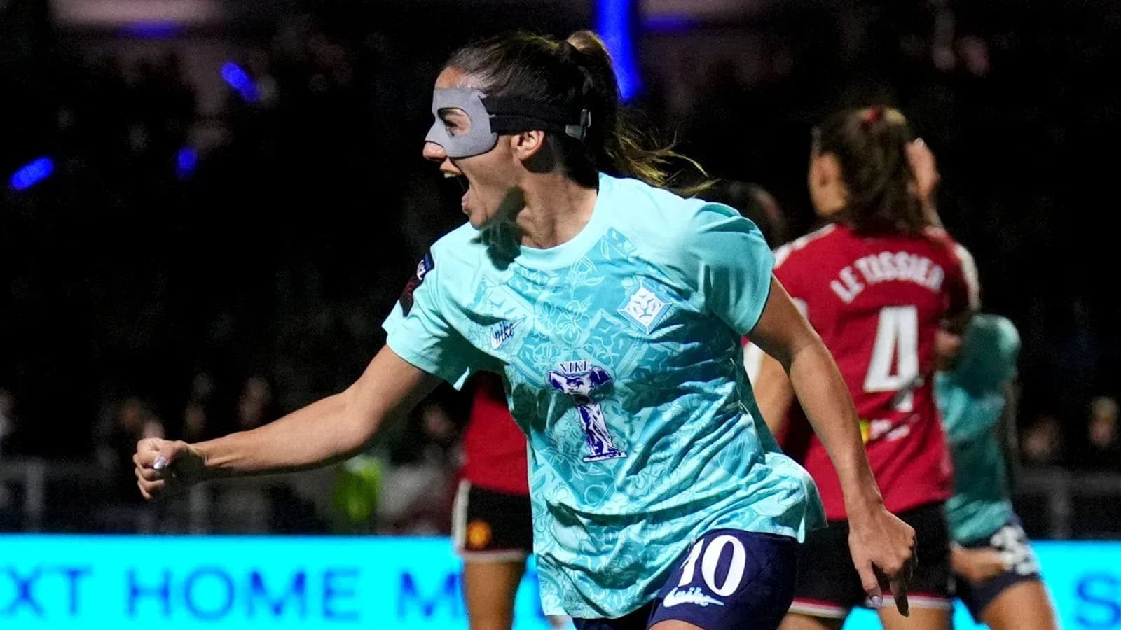 Jugadora celebrando un gol con una máscara facial Jugadora celebrando un gol con una máscara facial