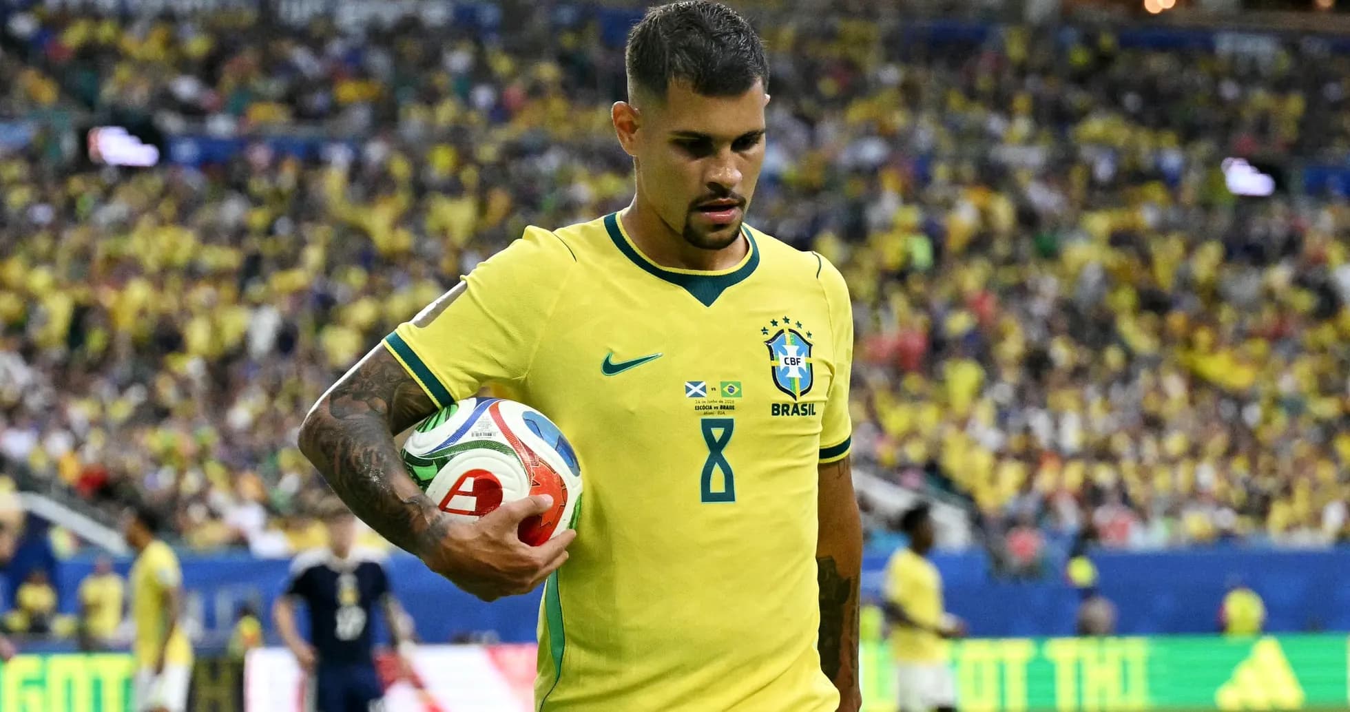Jugador brasileño sosteniendo un balón en el campo Jugador brasileño sosteniendo un balón en el campo