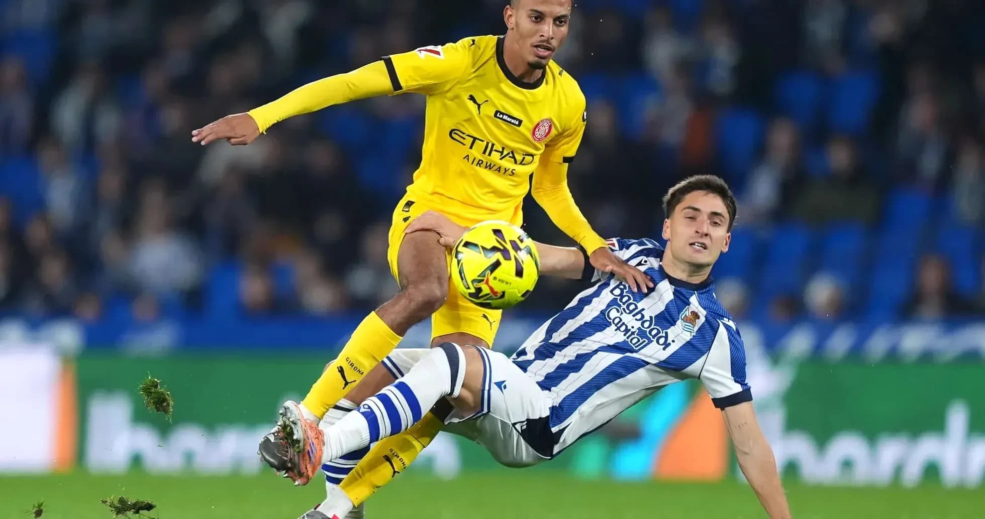 Jugador de Girona desafiando a un rival de Real Sociedad Jugador de Girona desafiando a un rival de Real Sociedad