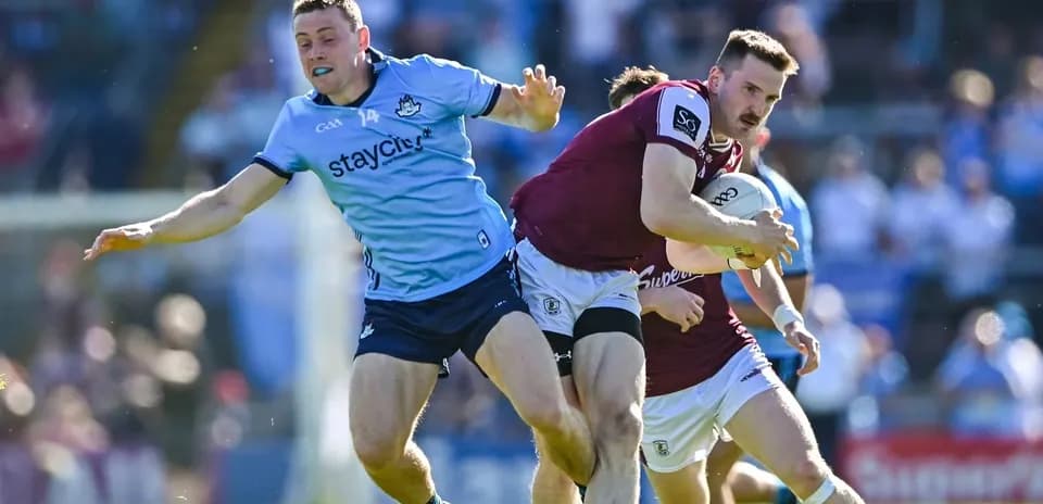 Jugador de Galway avanzando mientras es defendido por Dublín Jugador de Galway avanzando mientras es defendido por Dublín