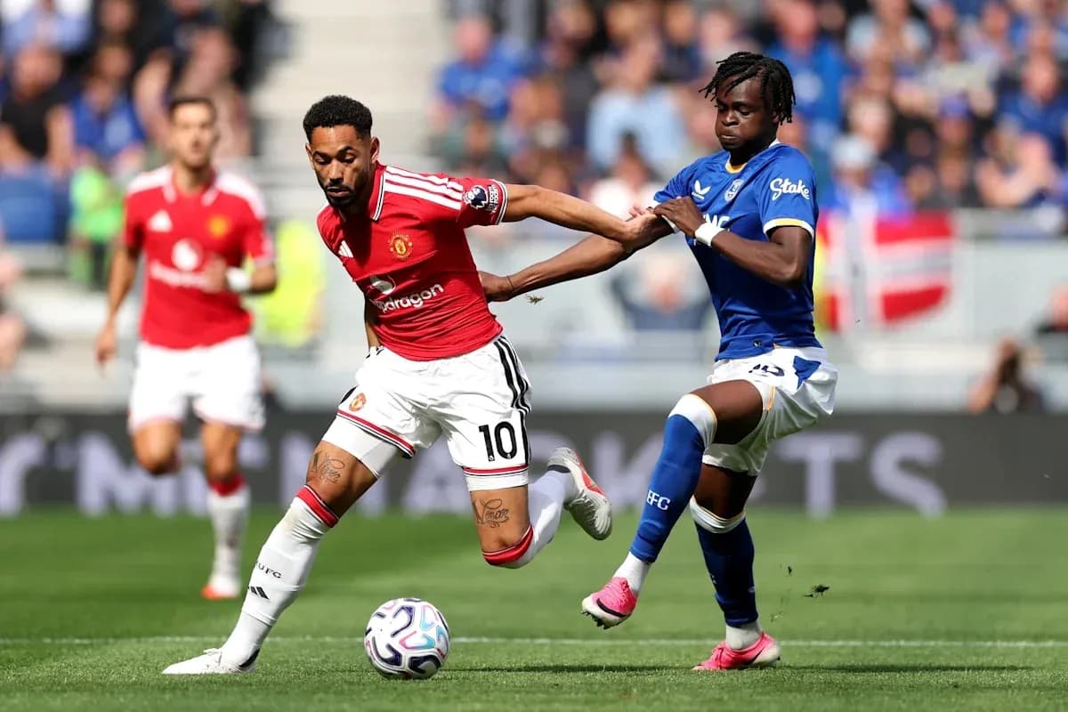 Jugador de Manchester United driblando mientras es marcado Jugador de Manchester United driblando mientras es marcado