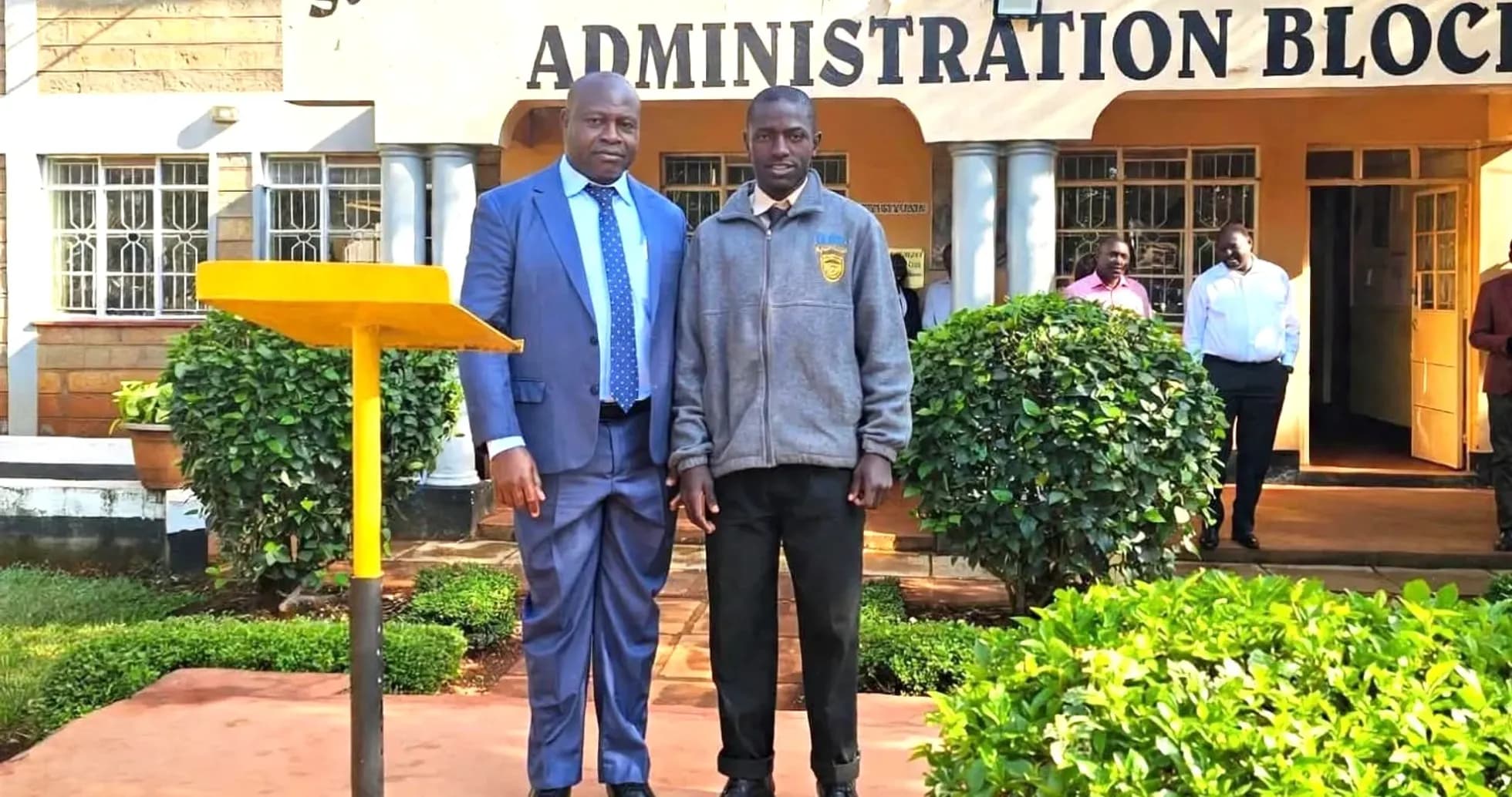 Dos hombres posando frente a la escuela secundaria Dos hombres posando frente a la escuela secundaria