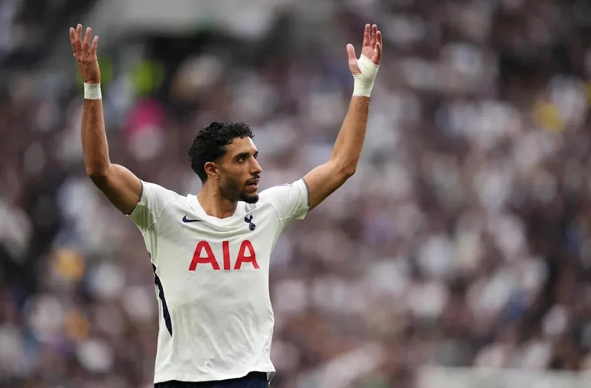 Jugador de Tottenham levantando las manos en el campo Jugador de Tottenham levantando las manos en el campo