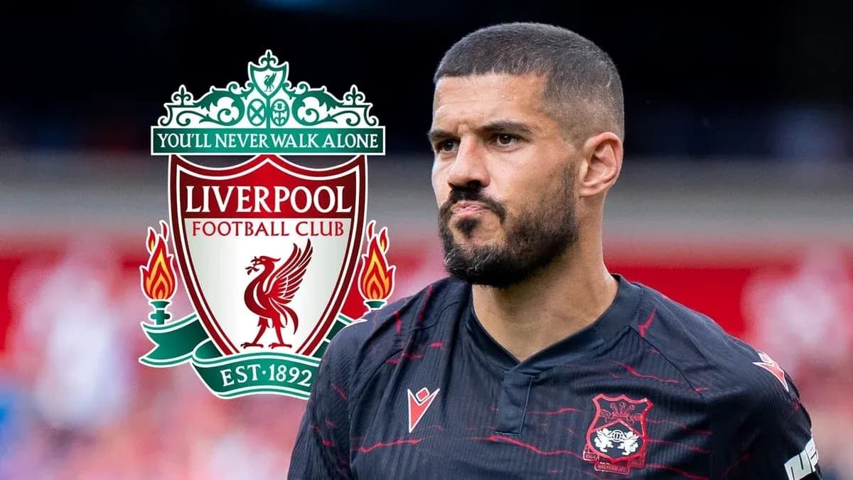 Jugador con camiseta negra junto al escudo de Liverpool Jugador con camiseta negra junto al escudo de Liverpool