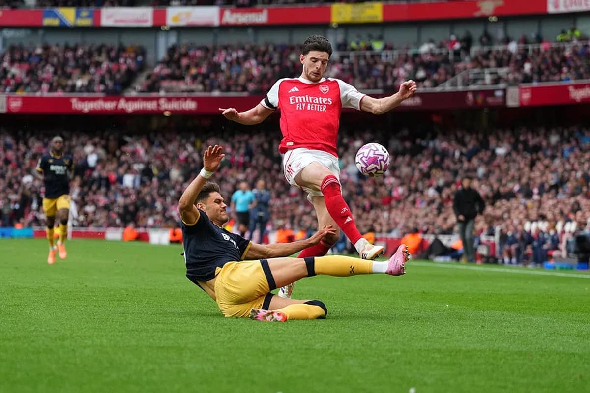 Jugador de Arsenal salta sobre oponente caído Jugador de Arsenal salta sobre oponente caído