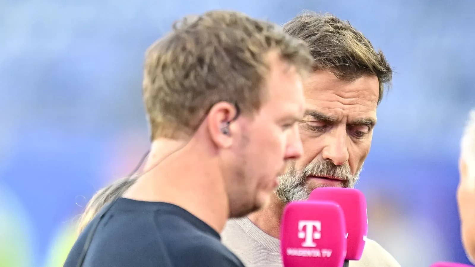 Dos comentaristas conversando en un evento deportivo Dos comentaristas conversando en un evento deportivo