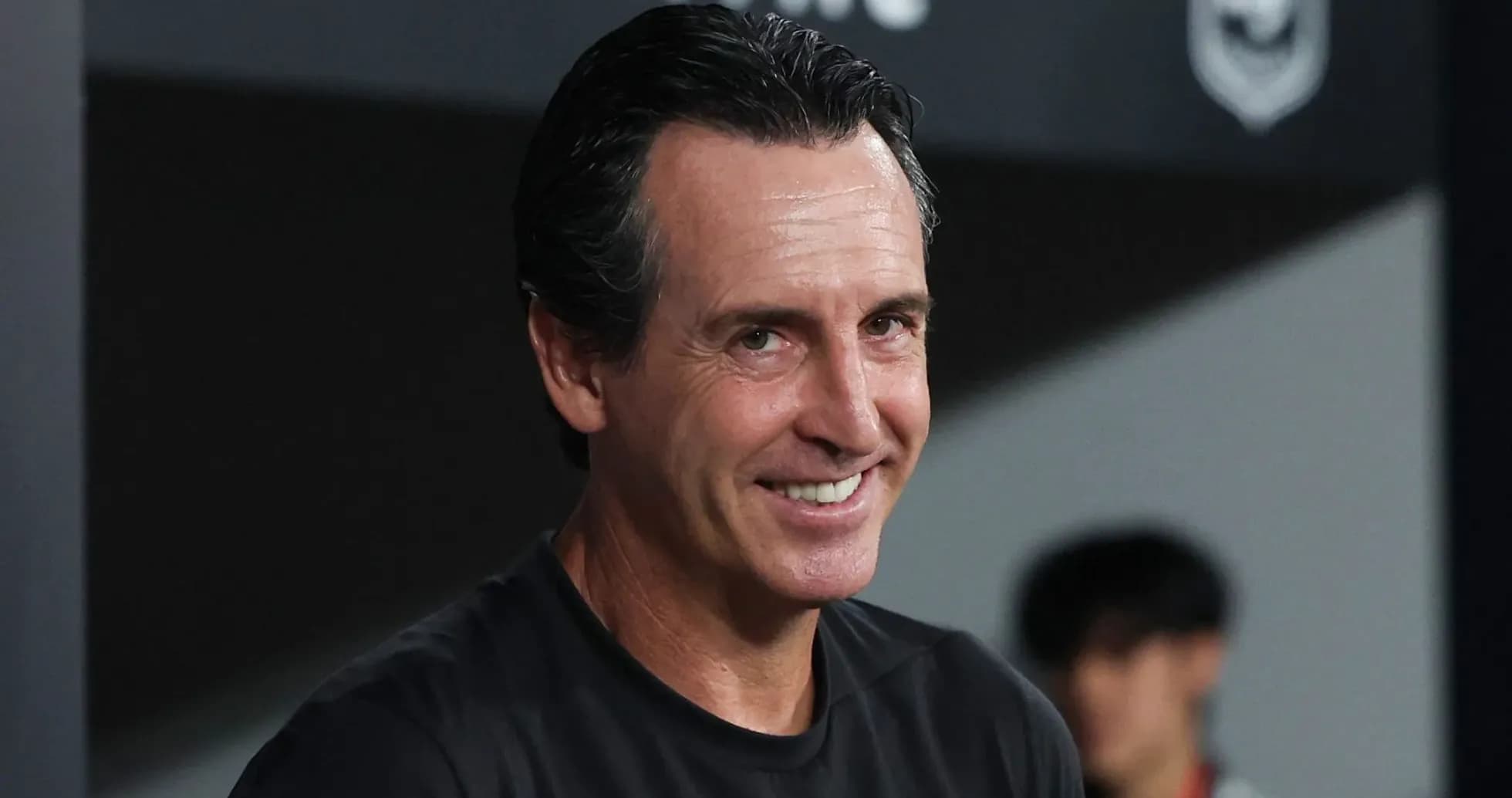 Entrenador sonriendo en banquillo durante partido Entrenador sonriendo en banquillo durante partido
