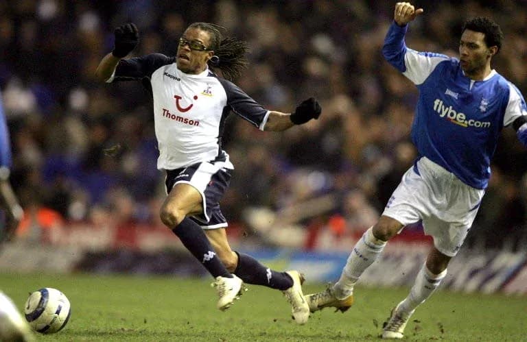 Jugador de Tottenham corriendo mientras es perseguido Jugador de Tottenham corriendo mientras es perseguido