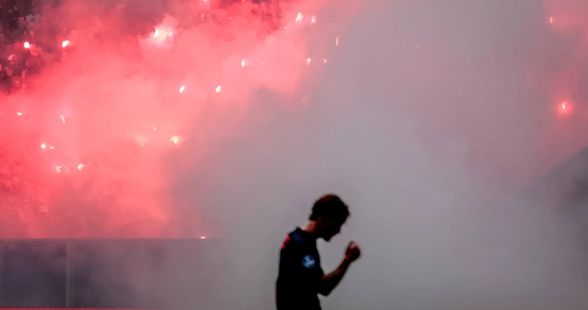 Jugador celebrando con humo de bengalas de fondo Jugador celebrando con humo de bengalas de fondo