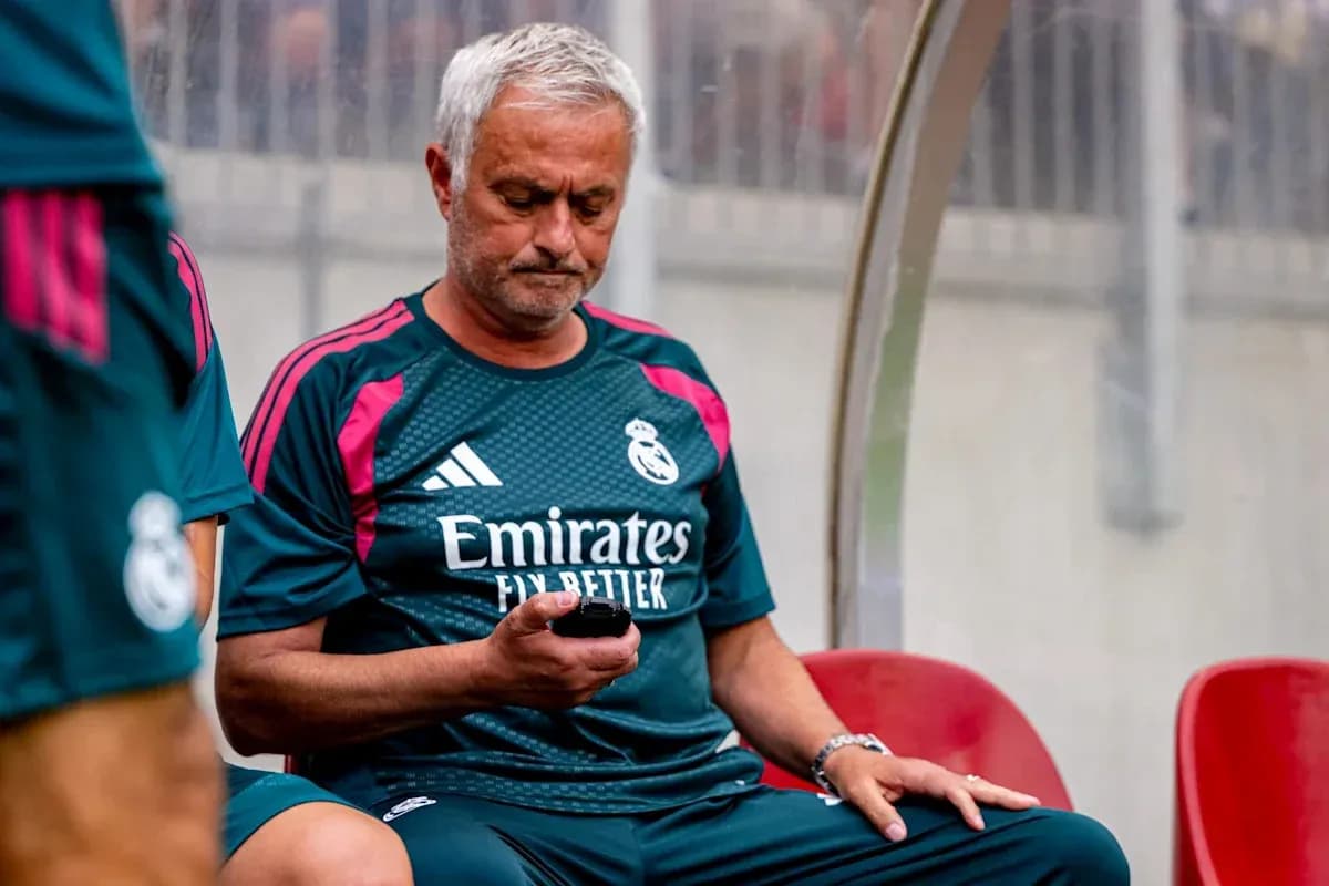 Entrenador sentado en el banquillo usando teléfono Entrenador sentado en el banquillo usando teléfono
