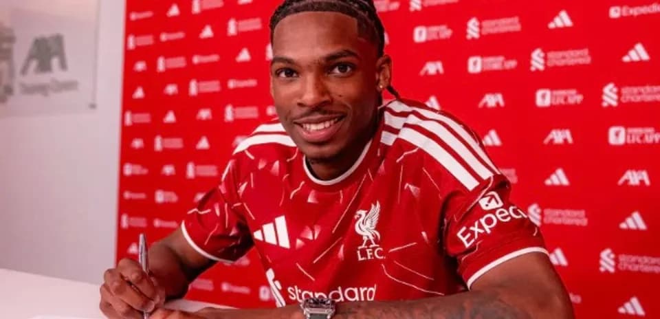 Jugador firmando contrato con camiseta del Liverpool Jugador firmando contrato con camiseta del Liverpool