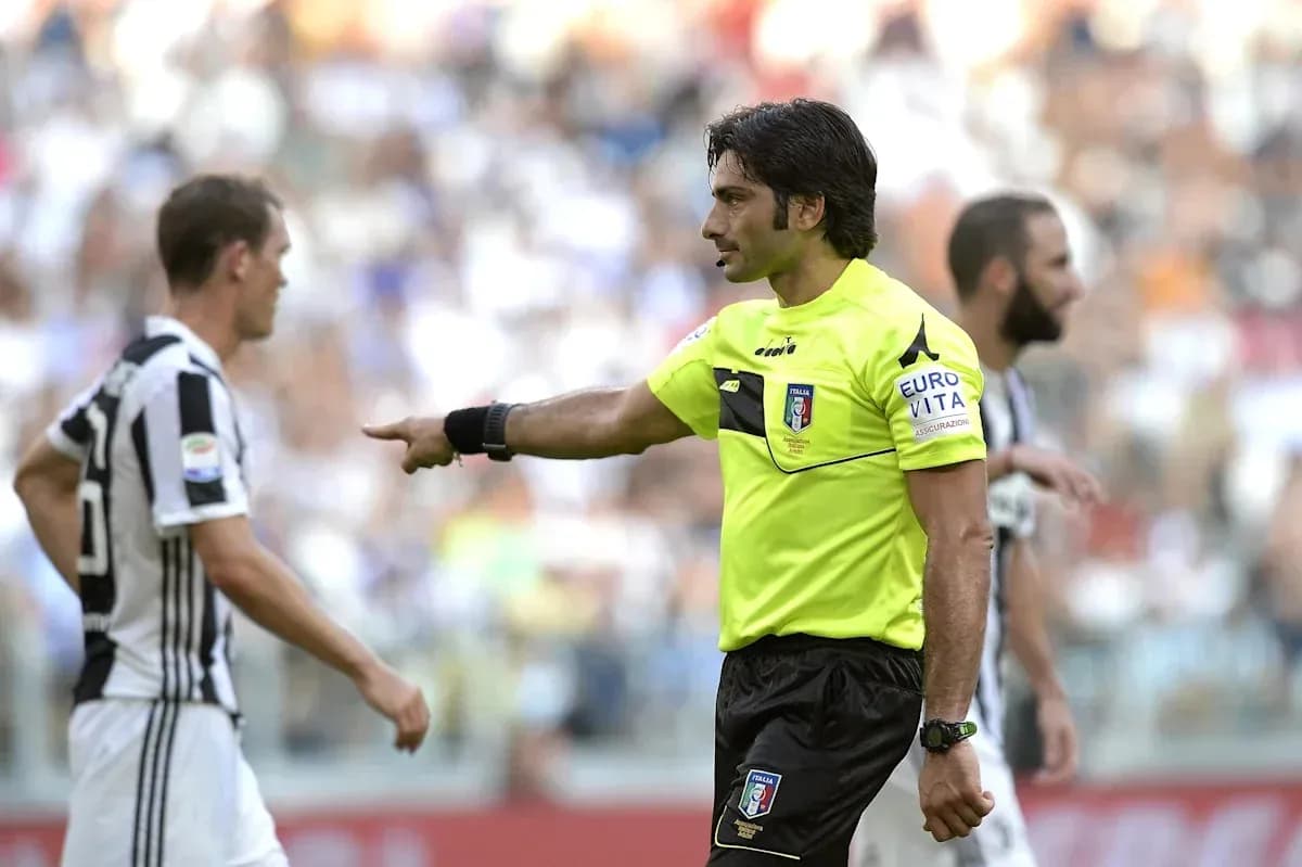 Árbitro señalando a jugador de Juventus durante partido Árbitro señalando a jugador de Juventus durante partido