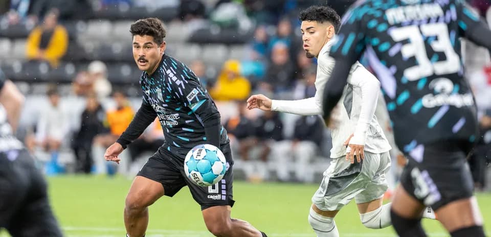 Jugador persigue el balón durante el partido Jugador persigue el balón durante el partido