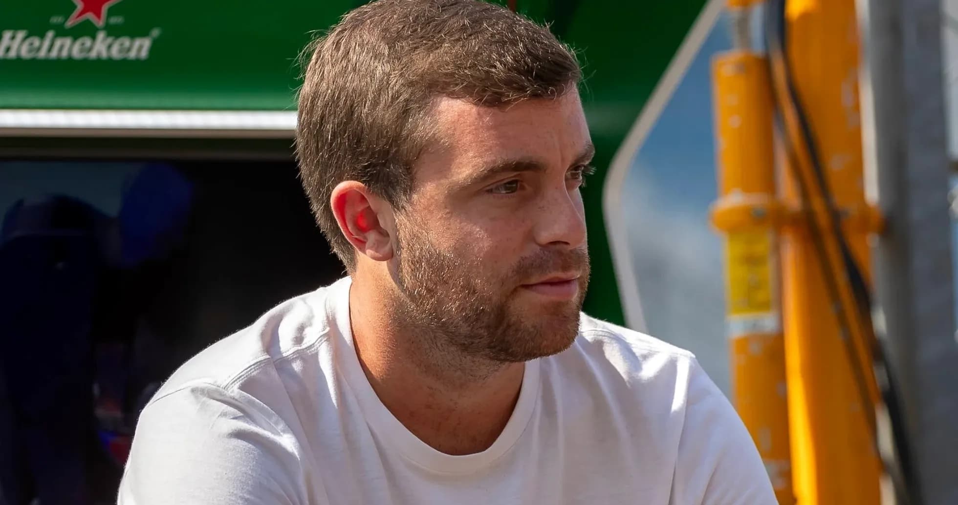 Hombre sentado, mirando hacia un lado en el paddock Hombre sentado, mirando hacia un lado en el paddock
