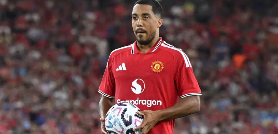 Jugador de Manchester United sosteniendo un balón en el campo Jugador de Manchester United sosteniendo un balón en el campo