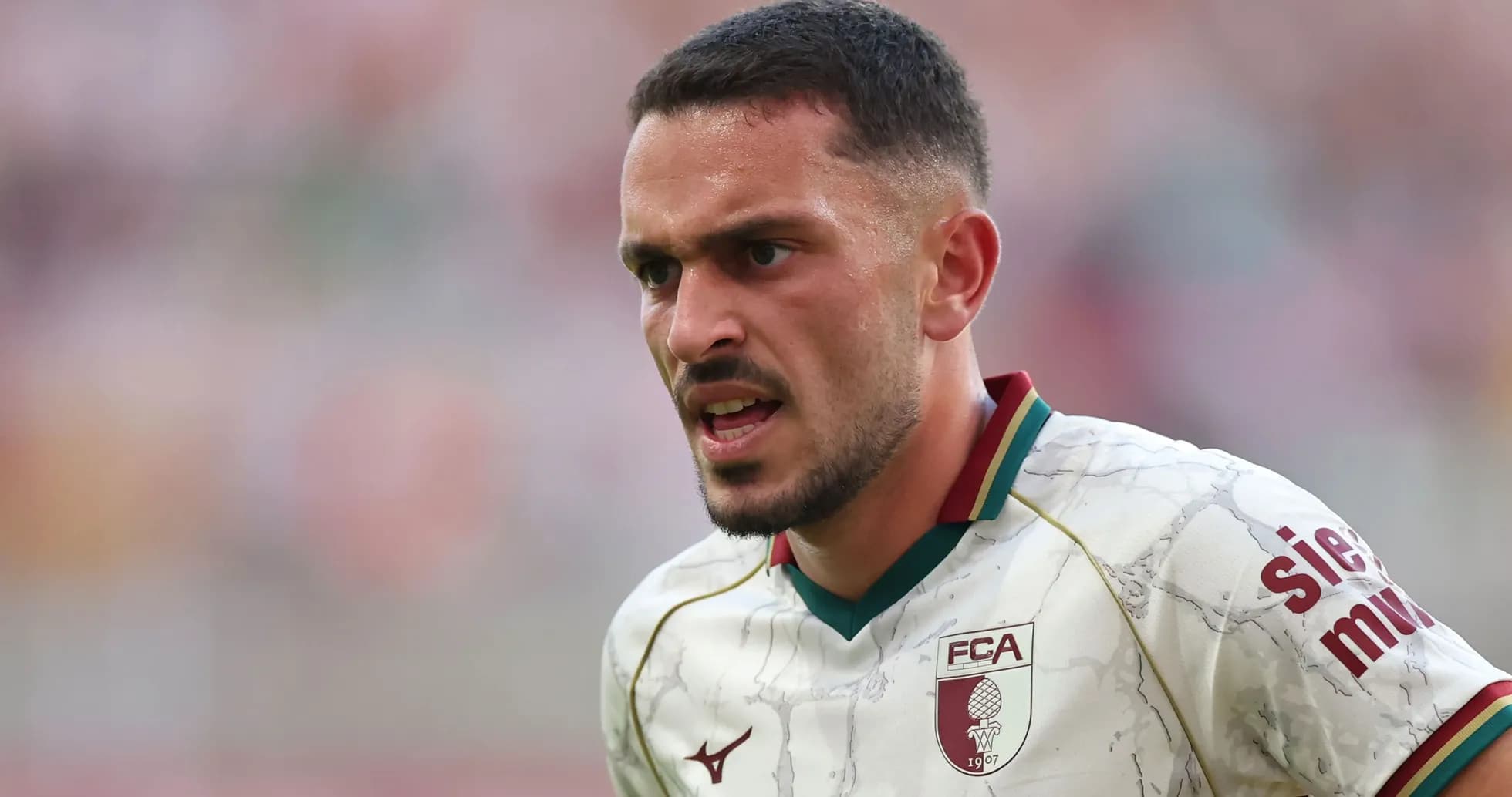 Jugador de fútbol con camiseta del FC Augsburg en acción Jugador de fútbol con camiseta del FC Augsburg en acción