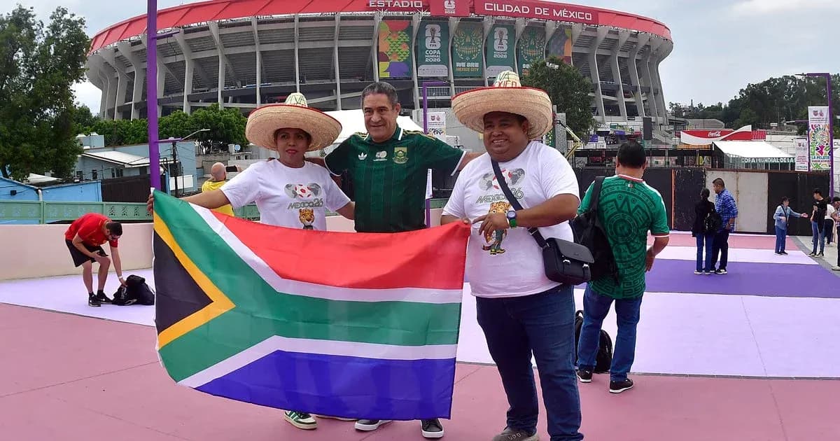 Tres aficionados sosteniendo bandera sudafricana en estadio Tres aficionados sosteniendo bandera sudafricana en estadio