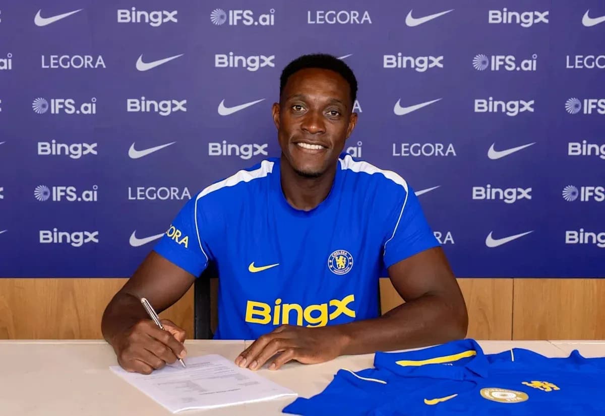 Jugador firmando contrato en mesa con camiseta Jugador firmando contrato en mesa con camiseta