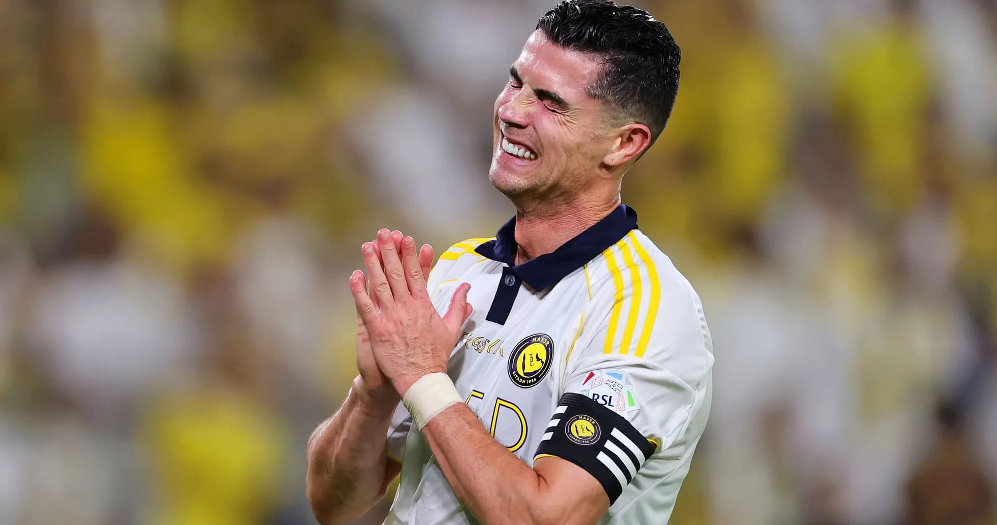 Jugador aplaudiendo durante partido con aficionados al fondo Jugador aplaudiendo durante partido con aficionados al fondo
