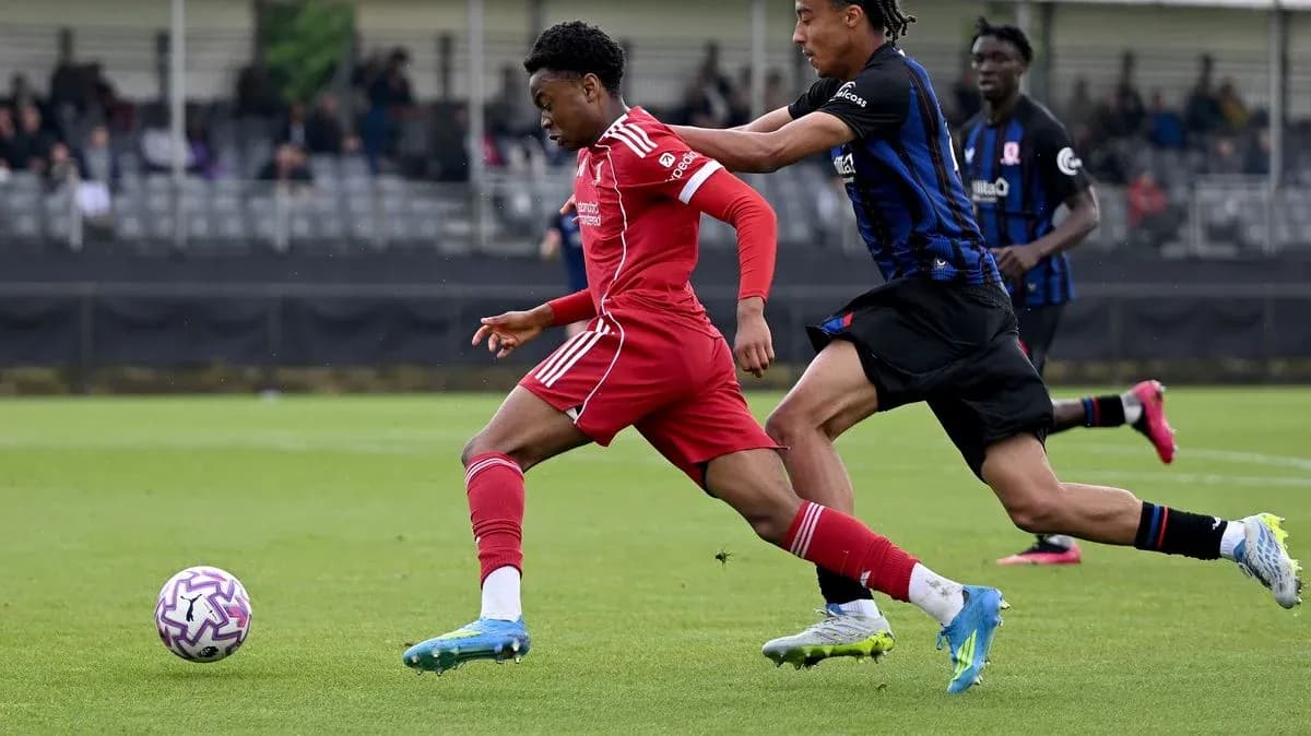 Jugador de Liverpool corriendo mientras es marcado por oponente Jugador de Liverpool corriendo mientras es marcado por oponente
