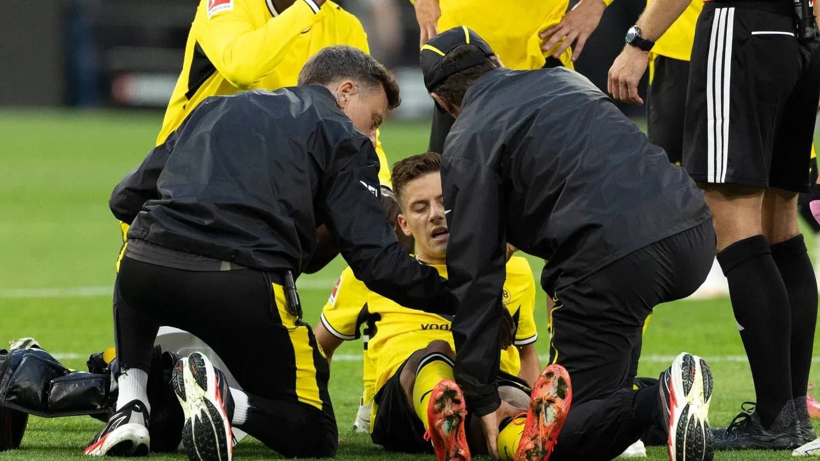 Jugadores y personal médico atendiendo a un jugador lesionado Jugadores y personal médico atendiendo a un jugador lesionado