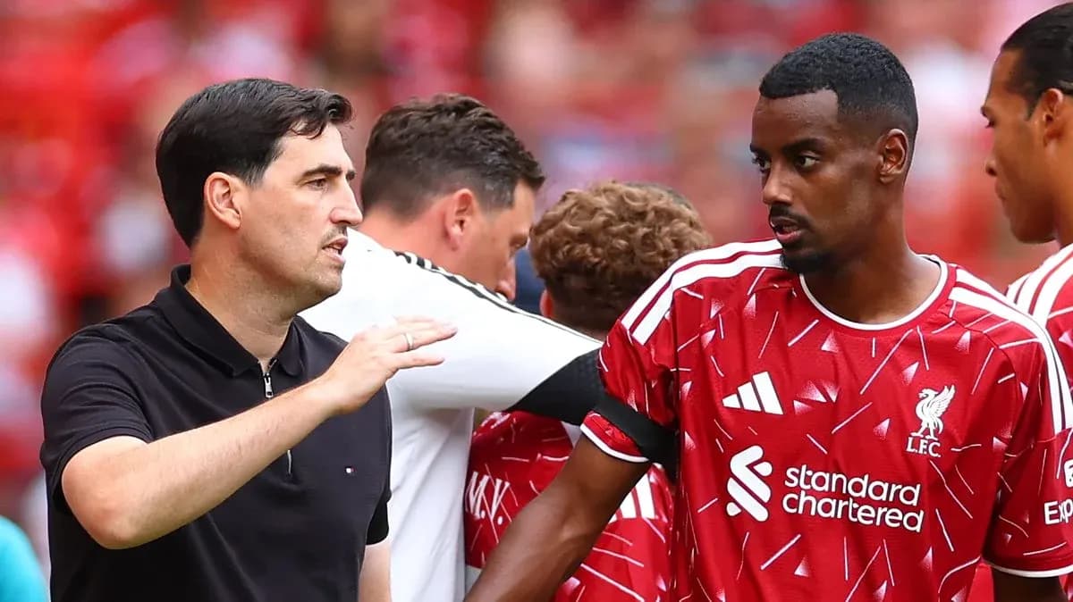 Entrenador hablando con jugador de Liverpool en banquillo Entrenador hablando con jugador de Liverpool en banquillo