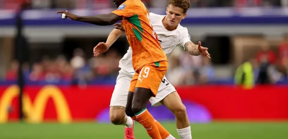 Jugador de naranja driblando a oponente en partido Jugador de naranja driblando a oponente en partido