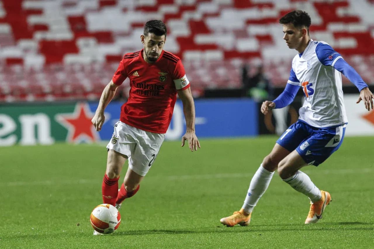 Jugador de Benfica driblando a rival de Lech Poznan Jugador de Benfica driblando a rival de Lech Poznan