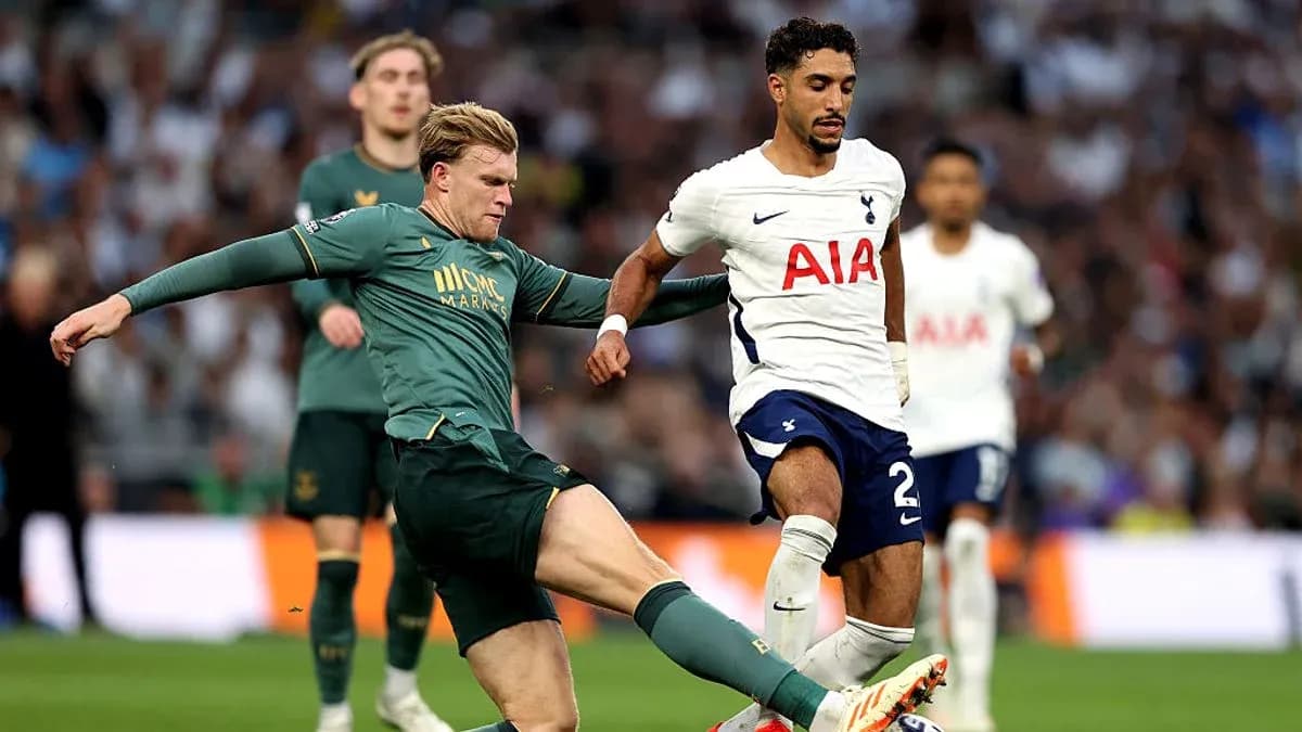Jugador de Tottenham driblando mientras es tackleado Jugador de Tottenham driblando mientras es tackleado