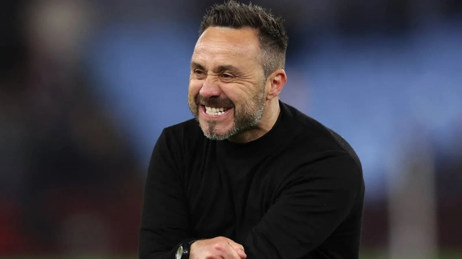 Entrenador sonriendo durante el partido Entrenador sonriendo durante el partido