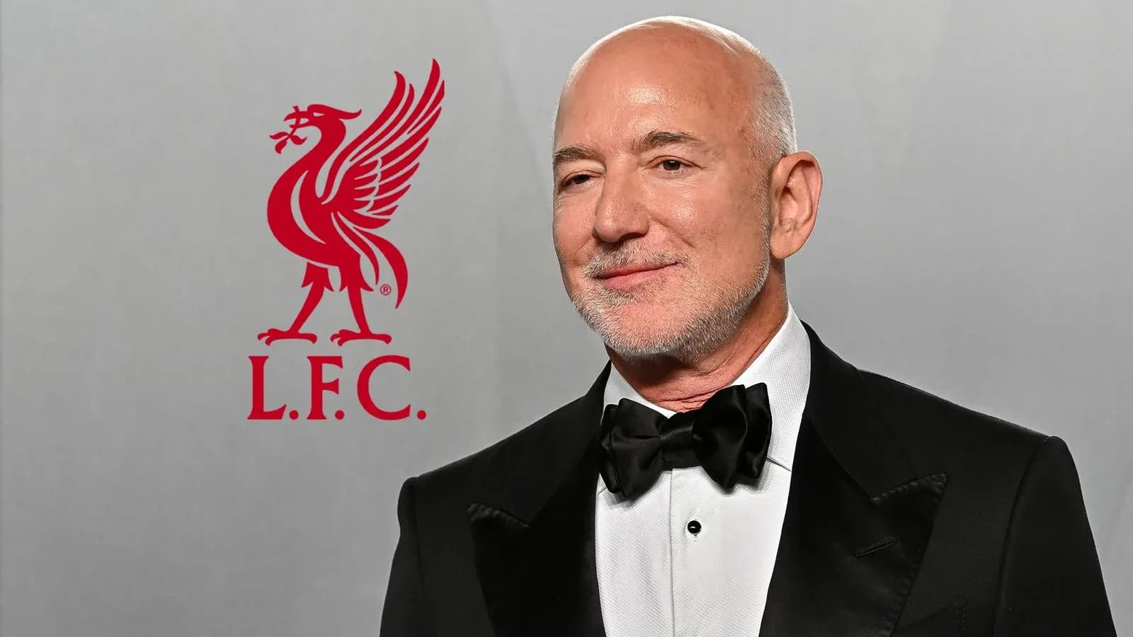 Hombre con traje en evento con logo de Liverpool Hombre con traje en evento con logo de Liverpool