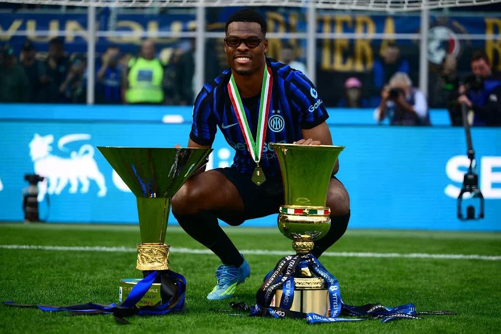 Jugador de Inter celebrando con trofeos en el campo Jugador de Inter celebrando con trofeos en el campo